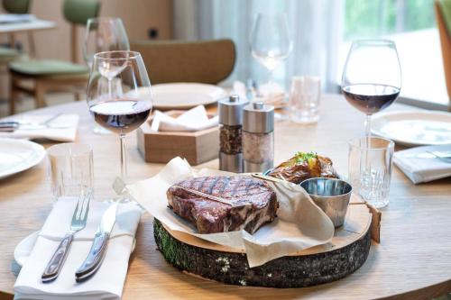 a table with a plate of meat and glasses of wine at Four Points by Sheraton Ljubljana Mons in Ljubljana