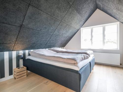 een slaapkamer met een groot bed op zolder bij Holiday home Fanø XIV in Fanø