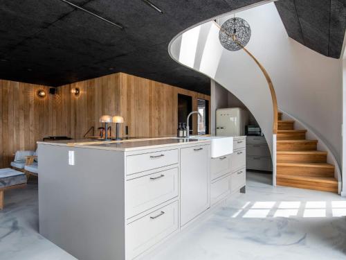 een keuken met witte kasten en een wenteltrap bij Holiday home Fanø XIV in Fanø