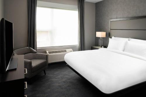ナティックにあるResidence Inn by Marriott Boston Natickの白いベッドと窓が備わるホテルルームです。