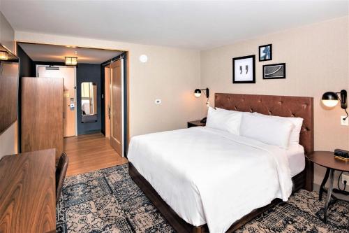 a hotel room with a bed and a desk and a table at Four Points by Sheraton Albany in Albany
