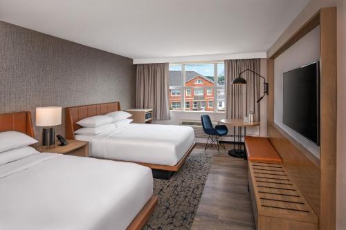 a hotel room with two beds and a flat screen tv at Sheraton Portsmouth Harborside Hotel in Portsmouth