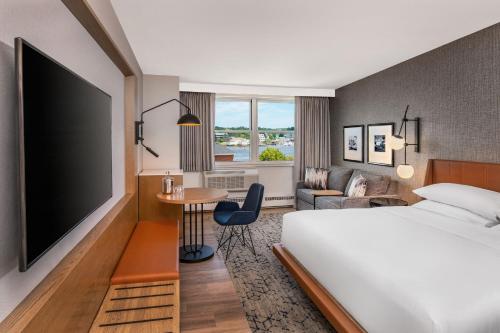 a hotel room with a bed and a flat screen tv at Sheraton Portsmouth Harborside Hotel in Portsmouth