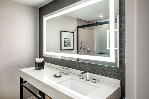 a bathroom with a sink and a large mirror at Sheraton Portsmouth Harborside Hotel in Portsmouth