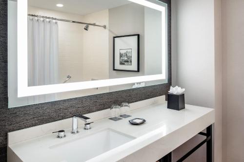 a bathroom with a white sink and a large mirror at Sheraton Portsmouth Harborside Hotel in Portsmouth