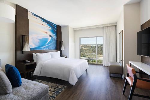 a hotel room with a white bed and a large window at San Diego Marriott Del Mar in San Diego