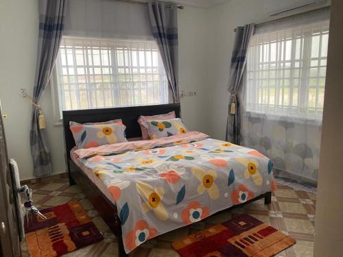 een slaapkamer met een bed met een kleurrijk dekbed bij Tadi, West Coast Lane in Inchaban