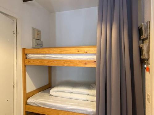 Ce lit superposé se trouve dans un dortoir doté d'un rideau. dans l'établissement Pied-à-terre au centre de Cauterets. 4 personnes., à Cauterets