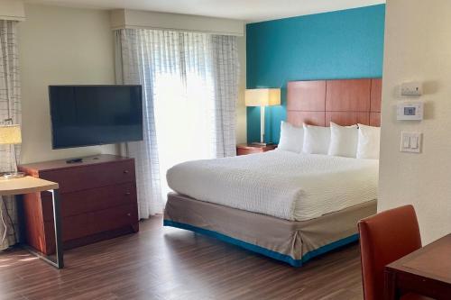 a hotel room with a bed and a flat screen tv at Residence Inn by Marriott Sacramento Airport Natomas in Sacramento