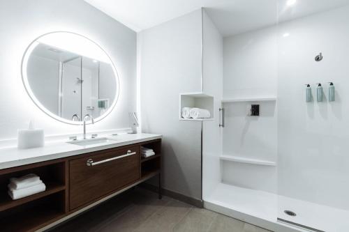 a bathroom with a sink and a shower with a mirror at Courtyard by Marriott Santa Barbara Downtown in Santa Barbara