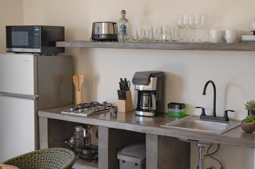 a kitchen counter with a sink and a refrigerator at Las 3 Carabelas BCS in El Sargento