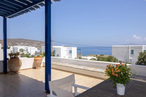 a balcony with flowers and a view of the ocean at Tinos Beautiful Sunrise Apartment Near Agios Sostis Beach in Agios Sostis