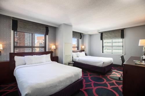 a hotel room with two beds and two windows at Courtyard by Marriott Boston Downtown in Boston