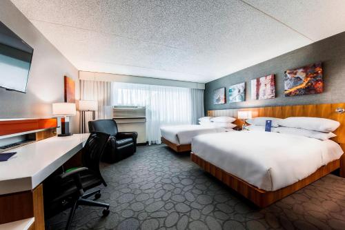 Delta Hotels by Marriott Fargo في فارغو: غرفة فندقية بسريرين ومكتب