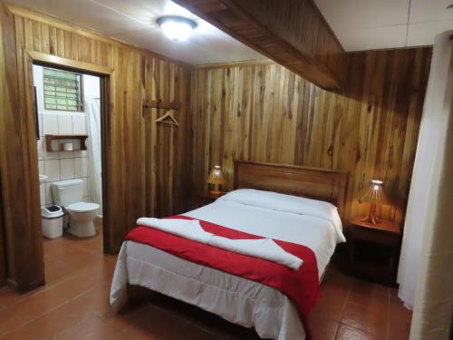 a bedroom with a large bed and a bathroom at Hospedaje Mariposa in Monteverde Costa Rica