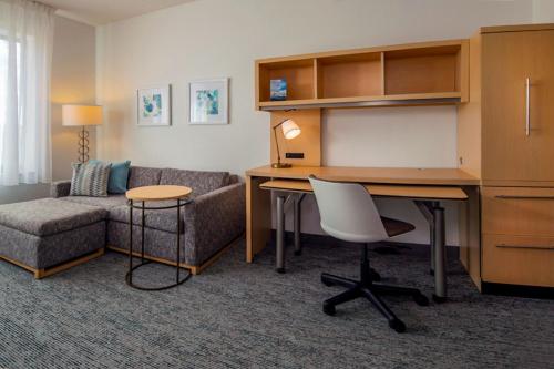 a room with a desk and a chair and a couch at TownePlace Suites by Marriott Frederick in Frederick