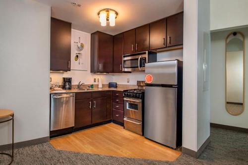 a kitchen with wooden cabinets and stainless steel appliances at TownePlace Suites by Marriott Frederick in Frederick