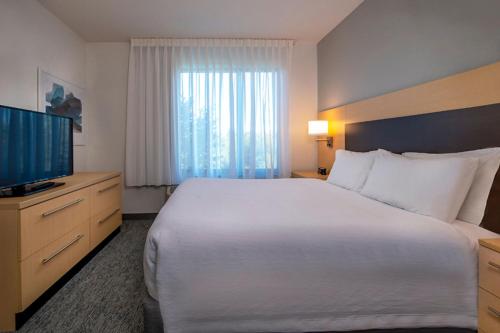 a hotel room with a large bed and a television at TownePlace Suites by Marriott Frederick in Frederick