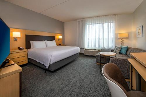 Habitación de hotel con cama y sofá en TownePlace Suites by Marriott Frederick en Frederick