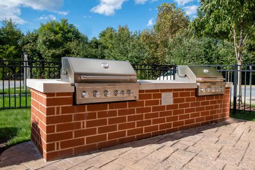 two bbqurgers sitting on a brick wall at TownePlace Suites by Marriott Frederick in Frederick