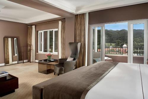 - une chambre avec un grand lit et un balcon dans l'établissement Penha Longa Resort, à Sintra