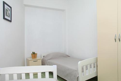 a bedroom with two white cribs and a small bed at Old town boulevard apartment in city center in Durrës