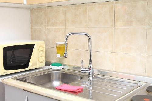 uma cozinha com um lavatório e um micro-ondas em Old town boulevard apartment in city center em Durrës