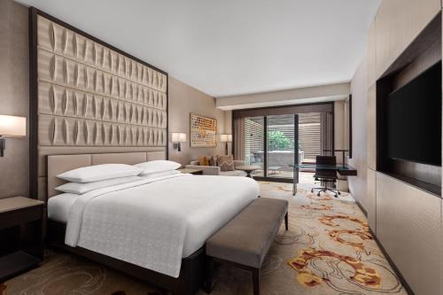 - une chambre avec un grand lit et une télévision dans l'établissement Sheraton Manila Hotel, à Manille