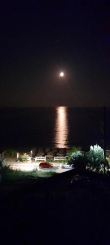 a view of the ocean at night with a moon at LEMONELIA, one big,4-5 people and one small apartment ,2-3 people in Loutsa