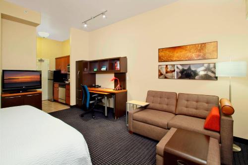 セントジョージにあるTownePlace Suites St. Georgeのベッド、ソファ、デスクが備わるホテルルームです。