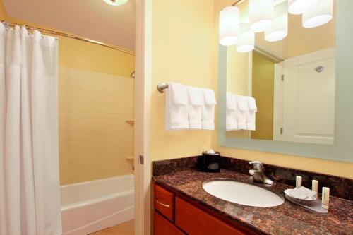 y baño con lavabo, espejo y ducha. en TownePlace Suites St. George, en St. George
