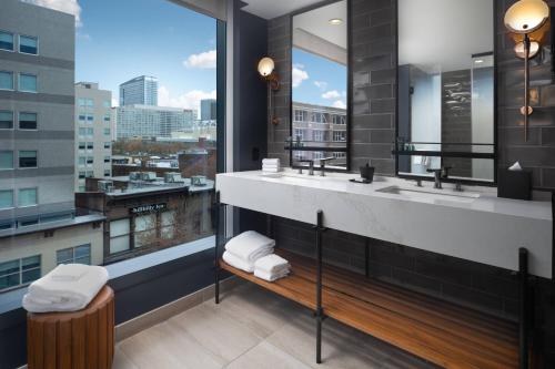 a bathroom with two sinks and a large window at Hotel Distil, Autograph Collection in Louisville