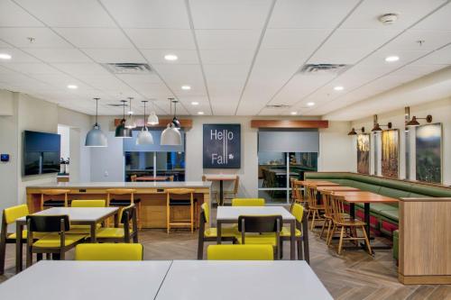 a dining room with tables and yellow chairs at Fairfield Inn & Suites by Marriott Cortland in Cortland