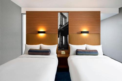 duas camas sentadas uma ao lado da outra num quarto em Aloft Brooklyn em Brooklyn