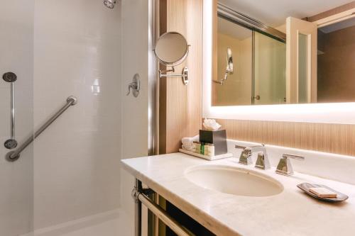 a bathroom with a sink and a shower and a mirror at Sheraton Tarrytown Hotel in Tarrytown