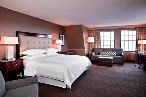 a hotel room with a large bed and a chair at Sheraton Parsippany Hotel in Parsippany