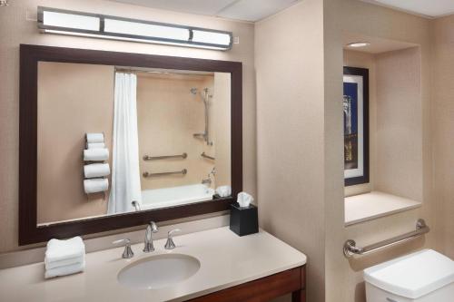 a bathroom with a sink and a mirror and a toilet at Sheraton Parsippany Hotel in Parsippany