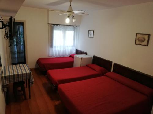 a living room with three red couches and a table at Necochea Real Hotel in Necochea