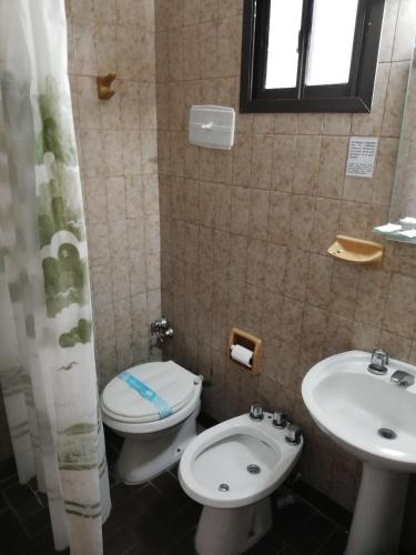 a bathroom with a toilet and a sink at Necochea Real Hotel in Necochea