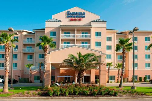 a hotel with palm trees in front of it at Fairfield Inn & Suites Orange Beach in Orange Beach