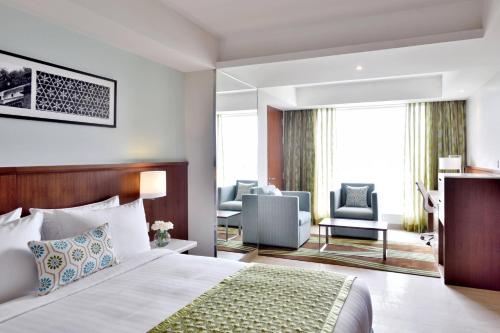 a hotel room with a bed and a living room at Fairfield by Marriott Indore in Indore