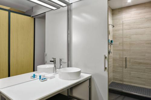 a bathroom with two sinks and a shower at Aloft Miami Airport in Miami