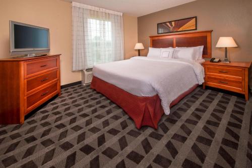 a bedroom with a bed and a flat screen tv at TownePlace Suites by Marriott Clinton at Joint Base Andrews in Clinton