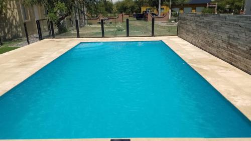 una piscina con agua azul en un patio trasero en Anan en Cortaderas