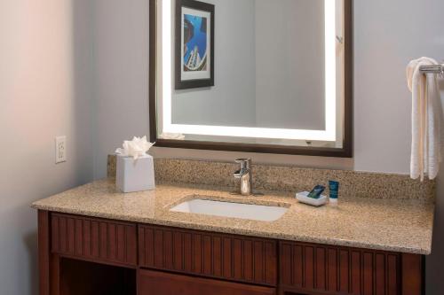 a bathroom with a sink and a mirror at Four Points by Sheraton Houston Hobby Airport in Houston