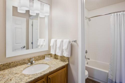 y baño con lavabo, bañera y espejo. en TownePlace Suites Minneapolis Eden Prairie, en Eden Prairie
