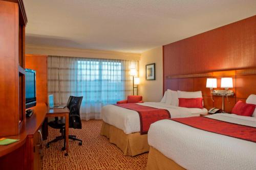 um quarto de hotel com duas camas e uma televisão em Courtyard Gulf Shores Craft Farms em Gulf Shores