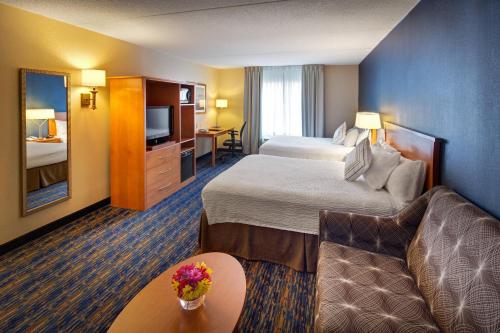 a hotel room with two beds and a couch at Fairfield Inn & Suites by Marriott Toronto Brampton in Brampton