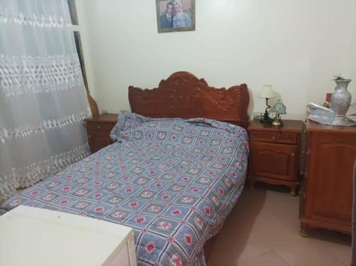 a bedroom with a bed with a blue comforter at Maison Latifa in Oujda
