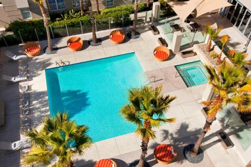 einen Blick über einen Pool mit Palmen in der Unterkunft Aloft Silicon Valley in Newark